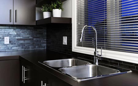 A double stainless steel kitchen sink with a single-handle faucet.